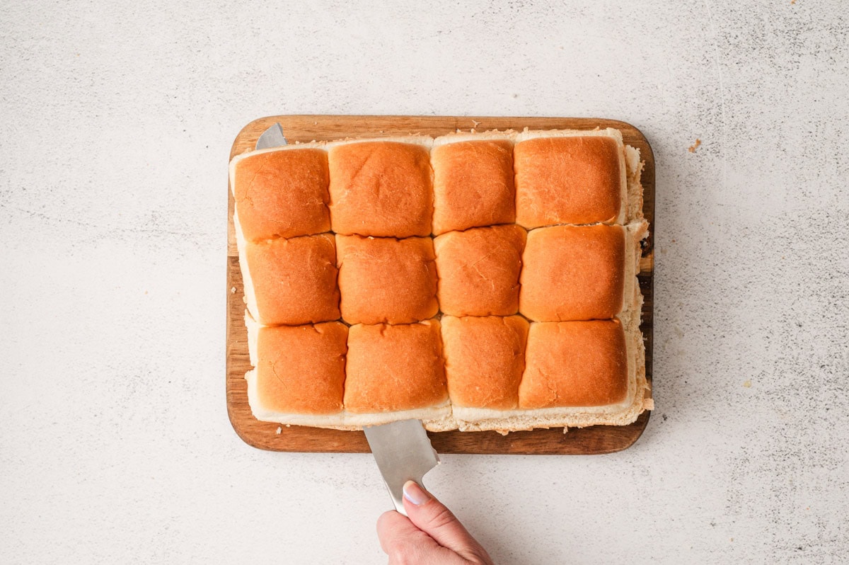 Slider buns being sliced in half.