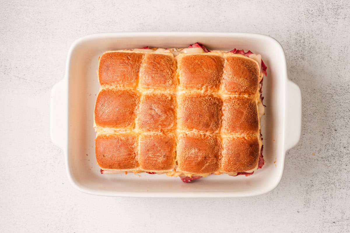 Baked Reuben sliders in a white casserole dish.