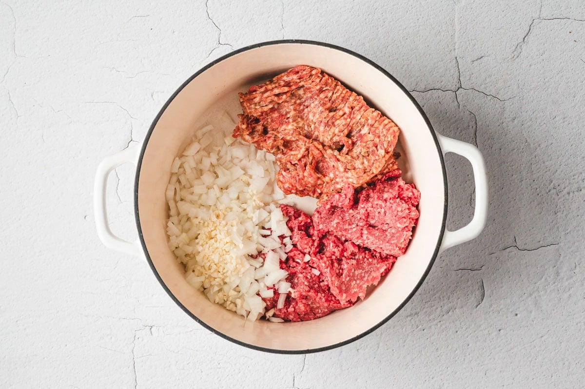 Sausage, ground beef, onions and garlic in a pot.