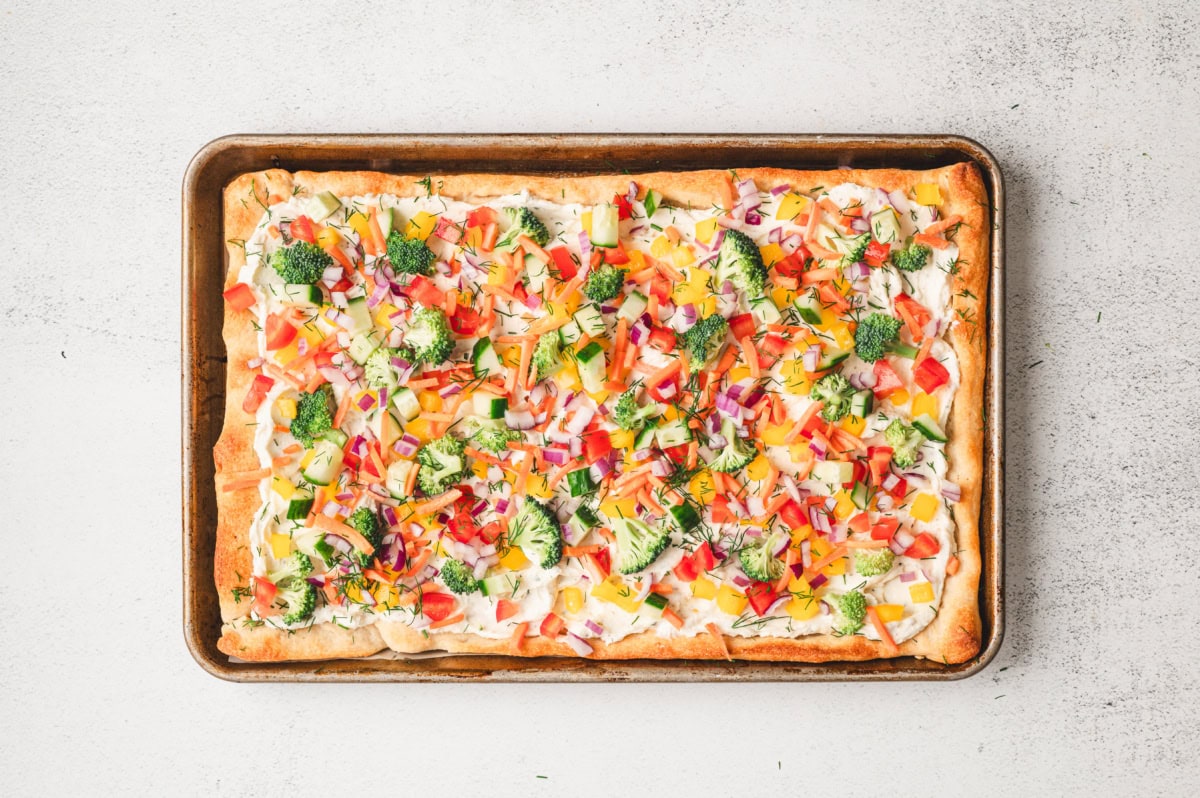 Fully baked veggie pizza on a sheet pan.