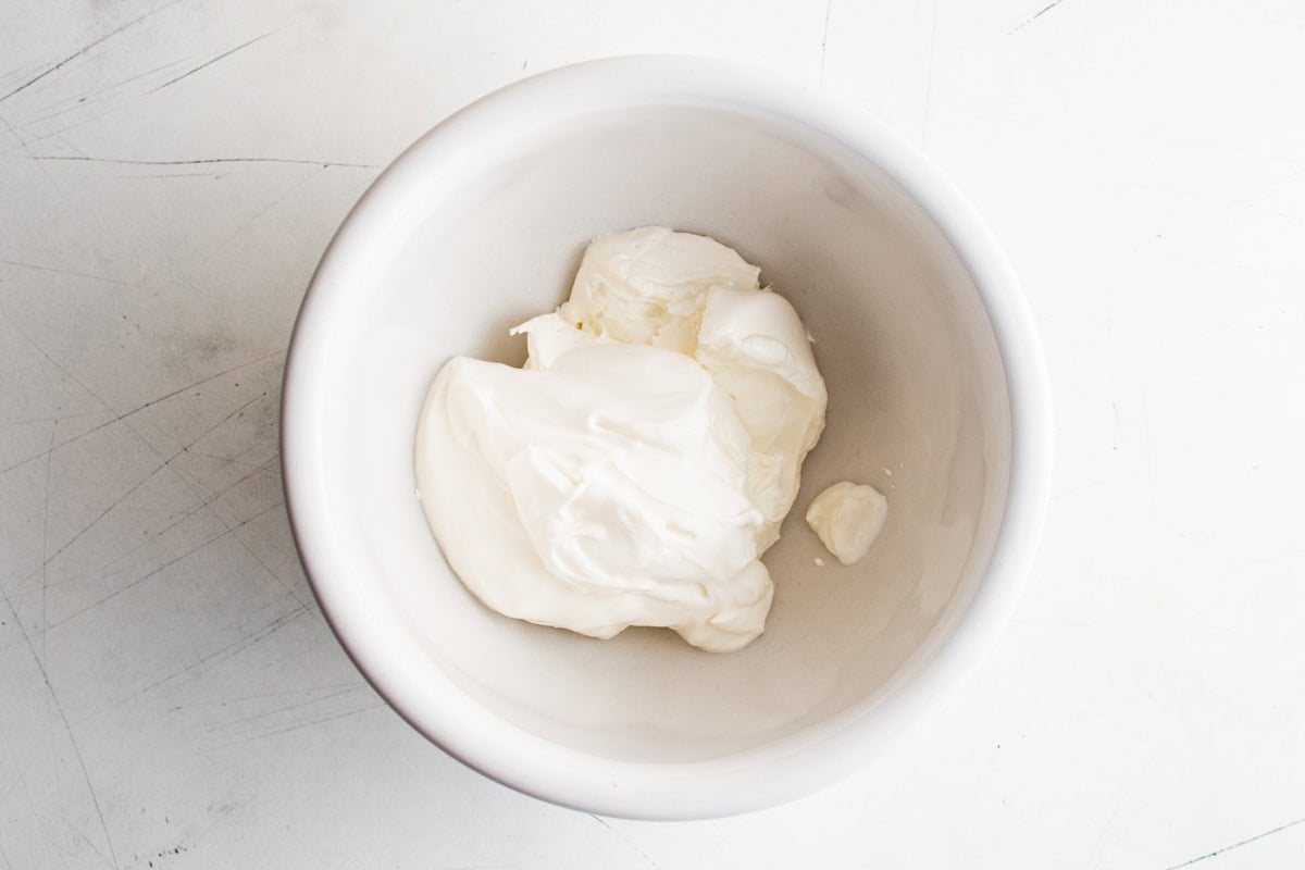 Softened cream cheese in a white bowl