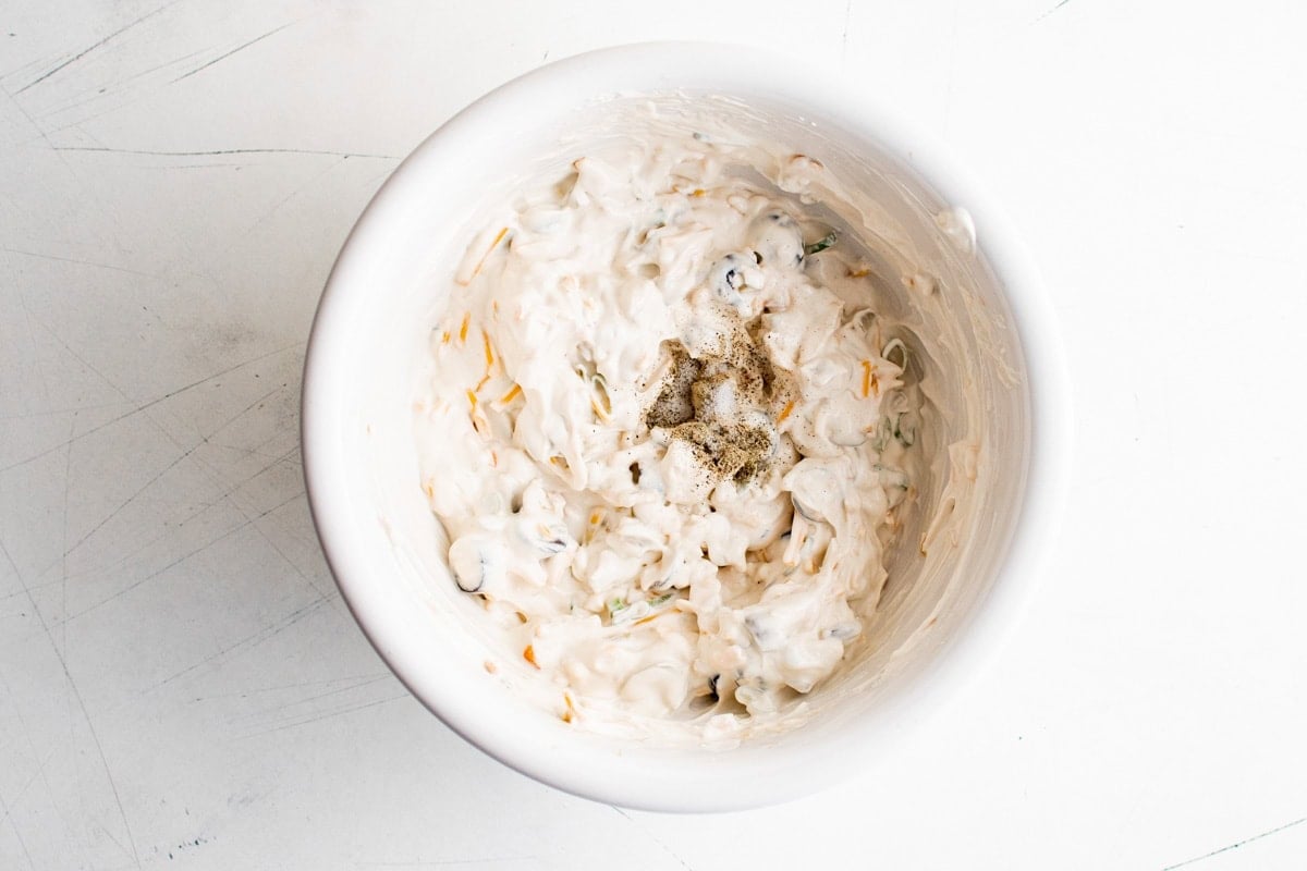 Creamy olive dip mixed together in a white bowl