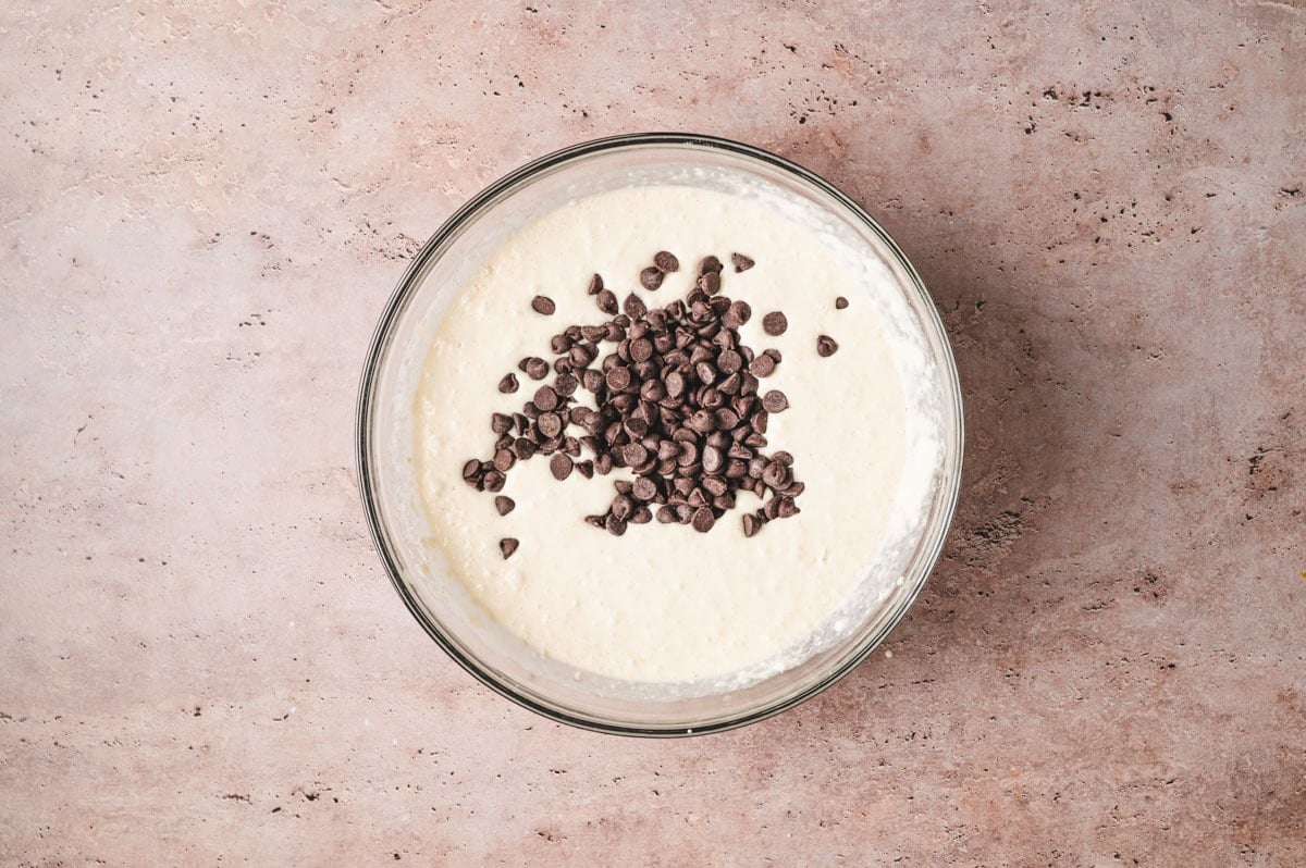 Pancake batter with chocolate chips in a glass bowl.