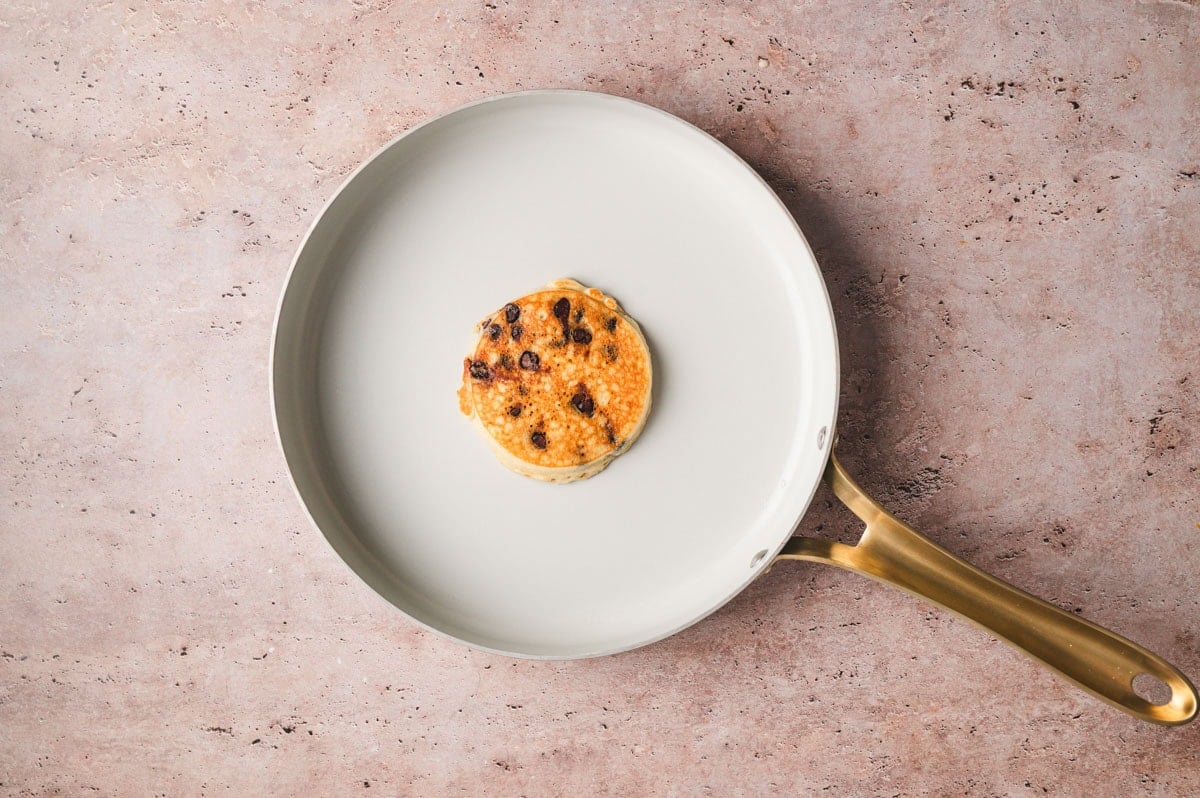 Cooked chocolate chip mini pancake on a skillet.