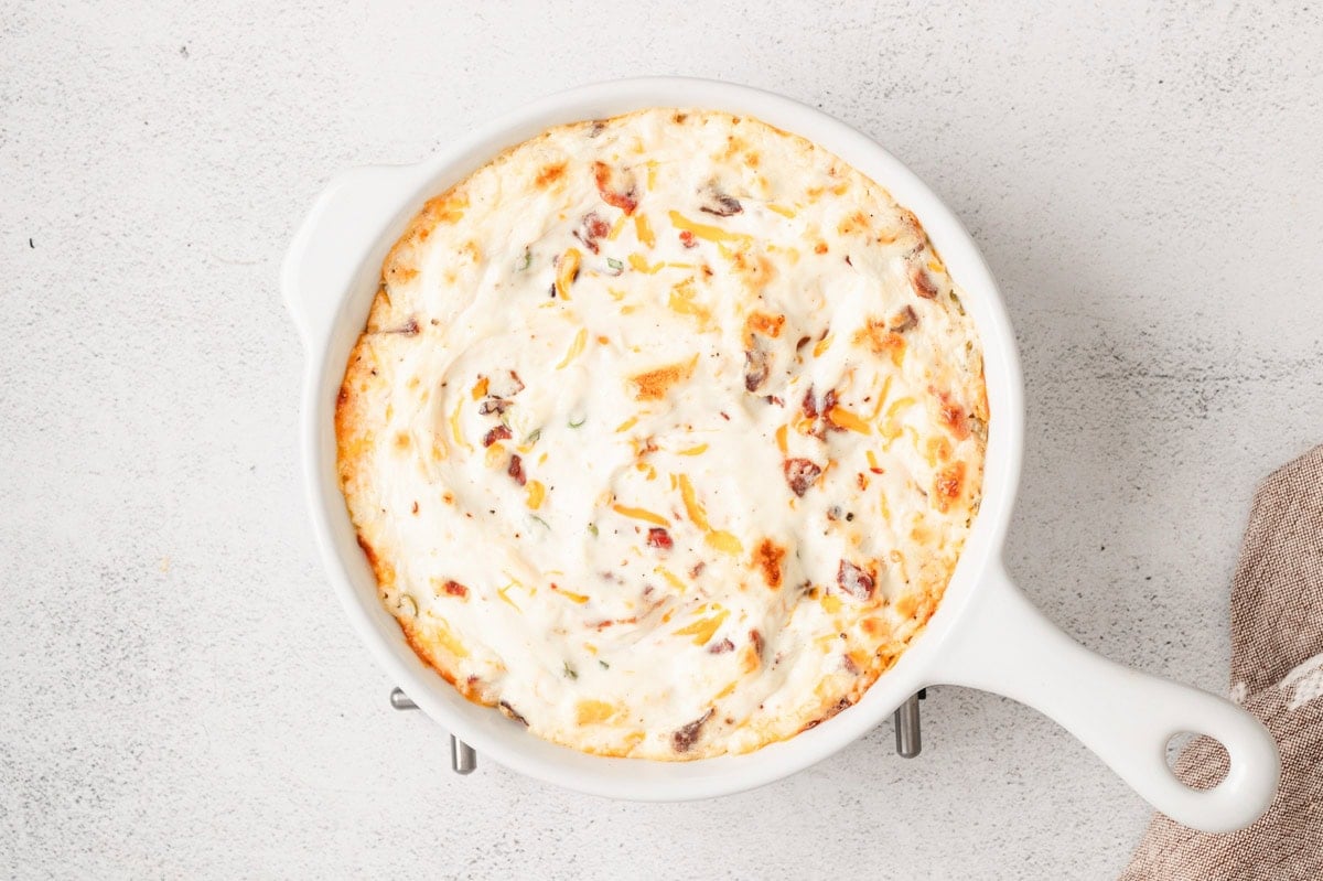 Baked hot bacon dip in a white baking dish.
