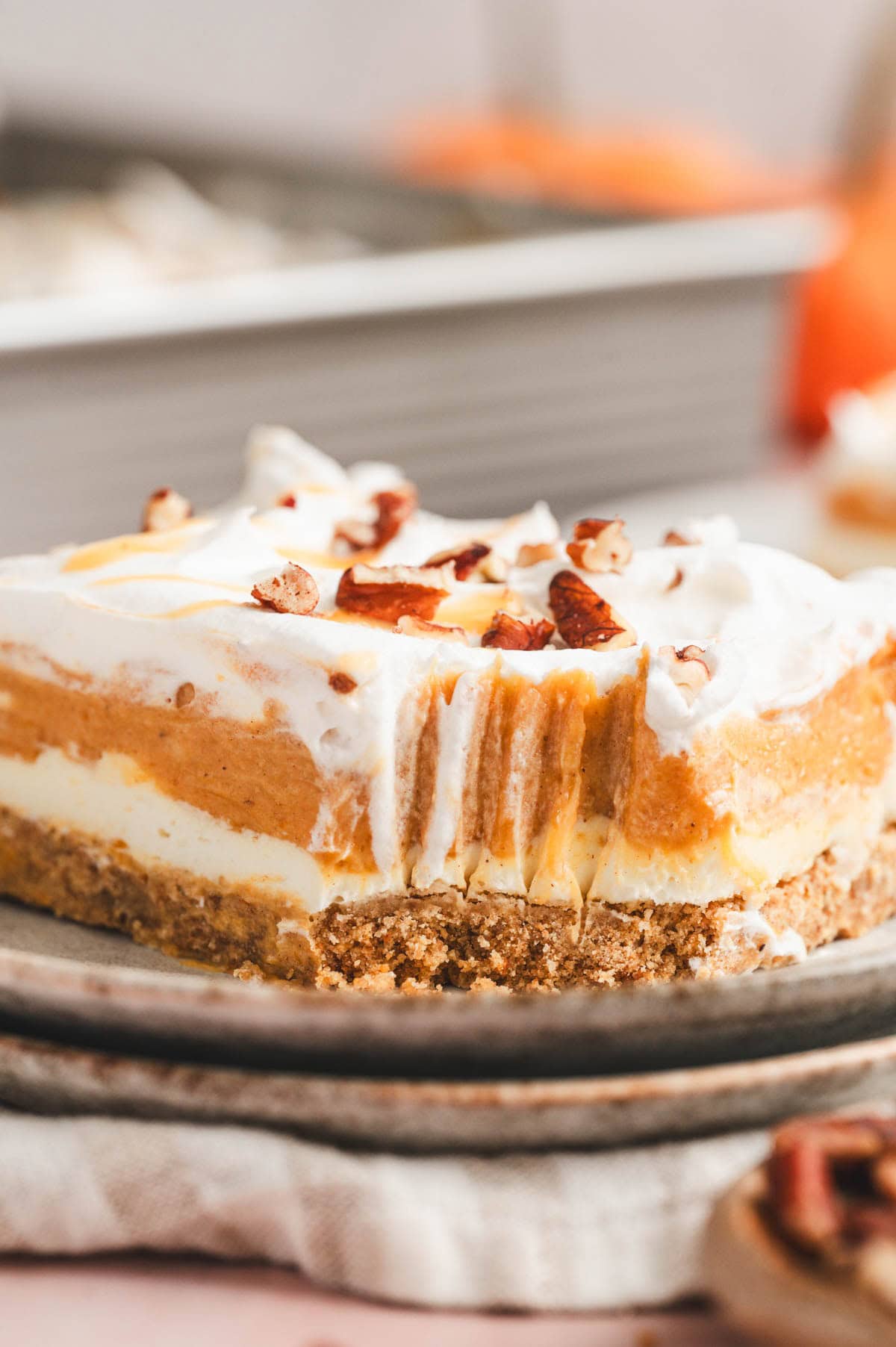 Pumpkin lasagna dessert on a plate with a bite missing.
