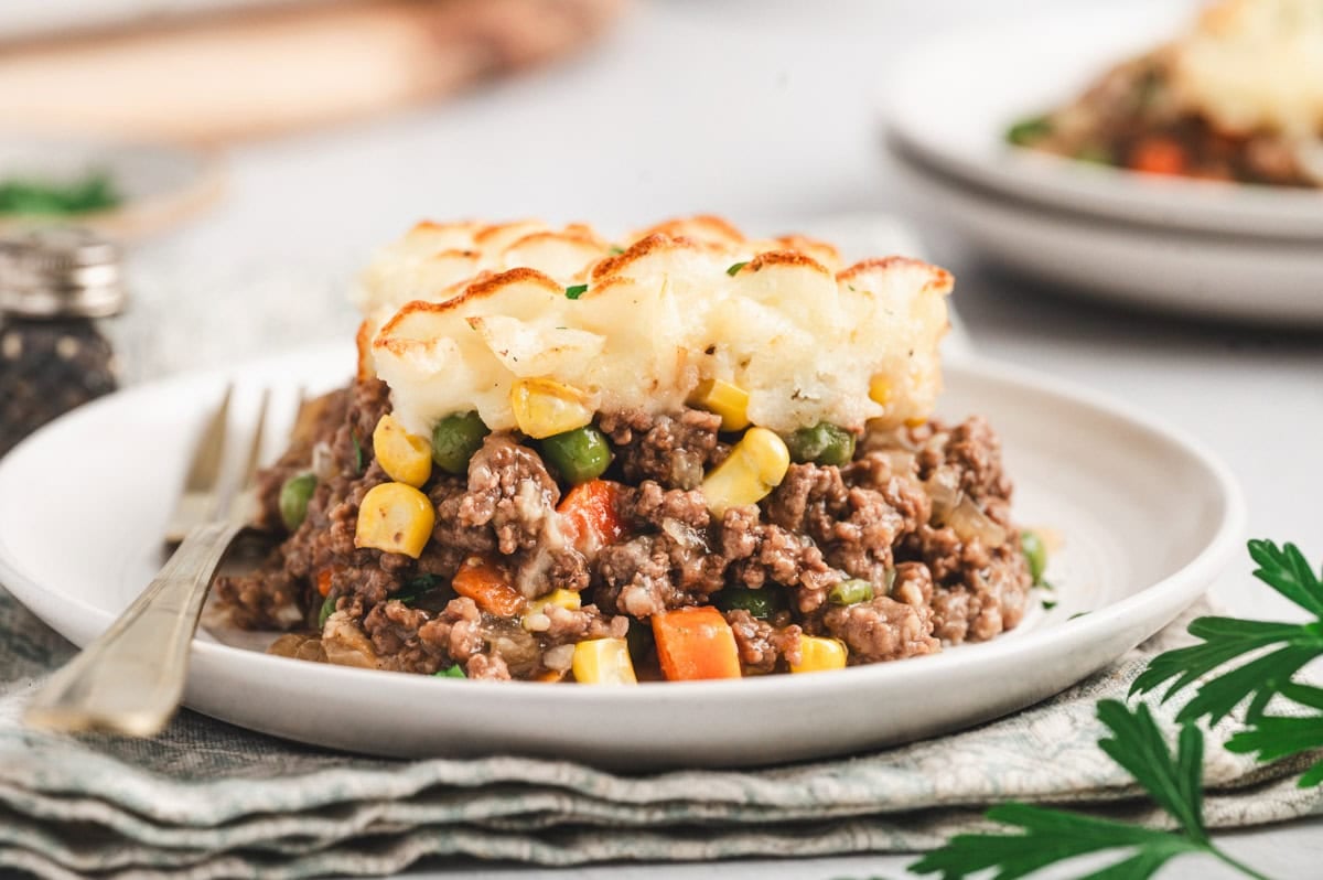 A piece of shepherd's pie on a white plate.