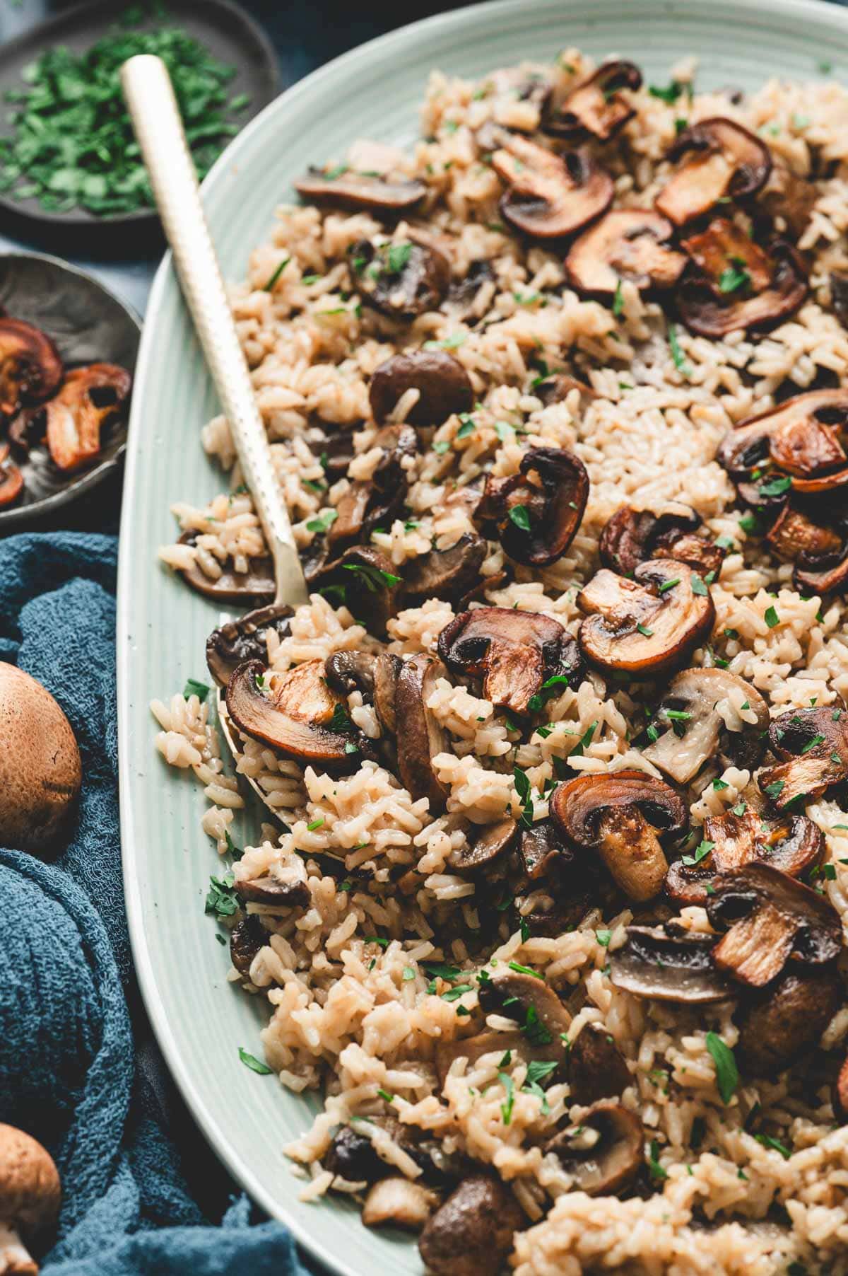 Mushroom rice in a serving platter with spoon.