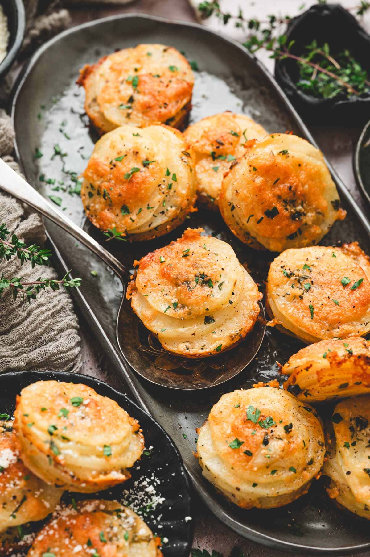 Crispy potato stacks on a black ceramic serving platter.