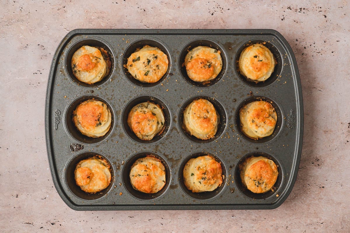 Baked crispy potato stacks in a muffin tin.