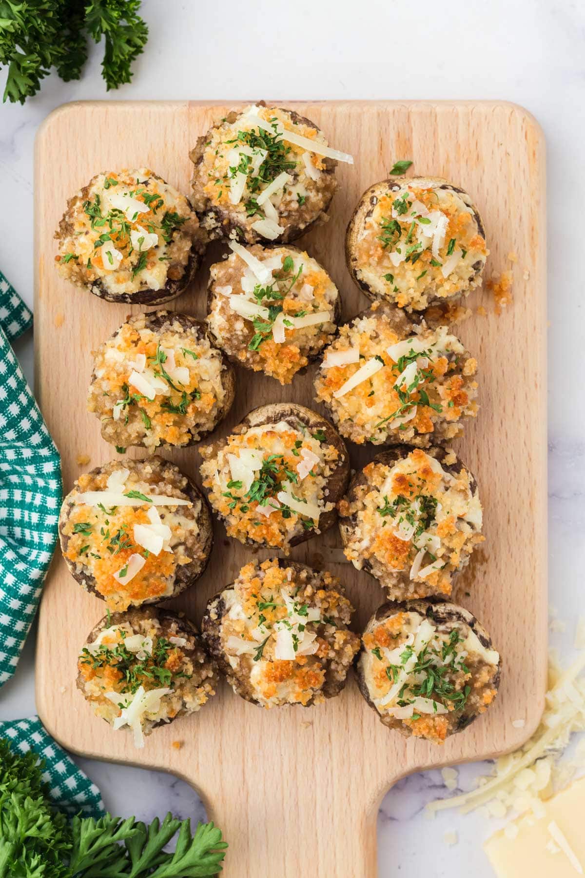 Baked stuffed mushrooms with breadcrumb topping with parmesan and herbs on a wooden board.