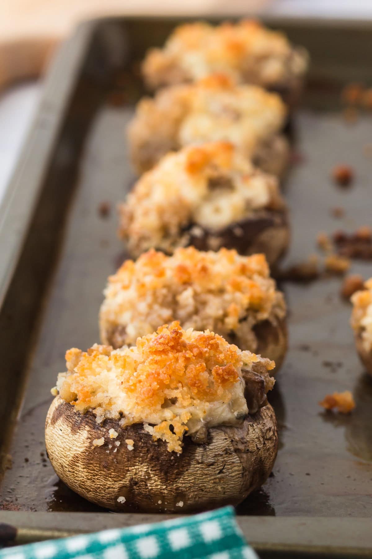Stuffed mushrooms with breadcrumb topping on a baking sheet.
