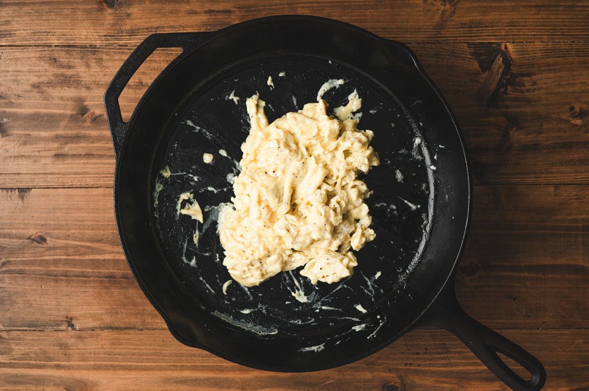 Scrambled eggs in a cast iron skillet.