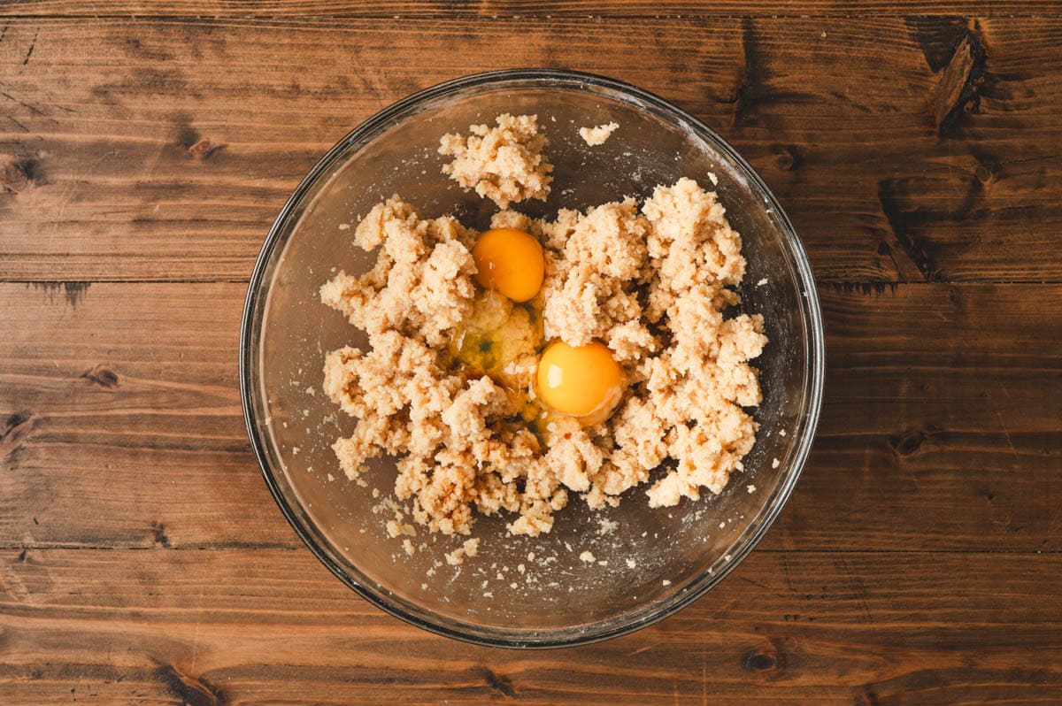 Creamed butter and sugar in glass bowl with eggs.