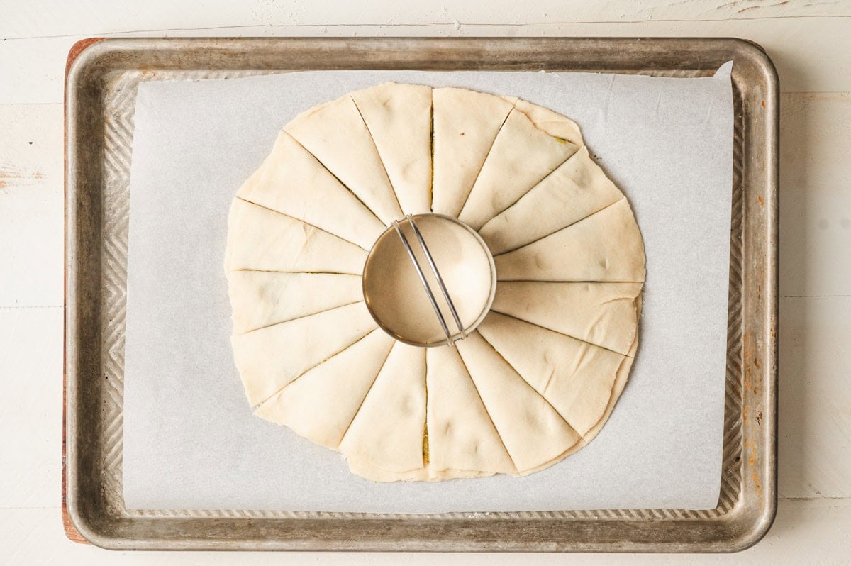 Star bread dough layered on top of each other with cuts and a biscuit cutter in the center.