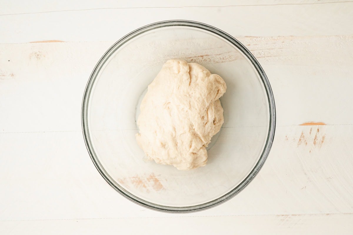 Star bread dough that has risen in a glass bowl.