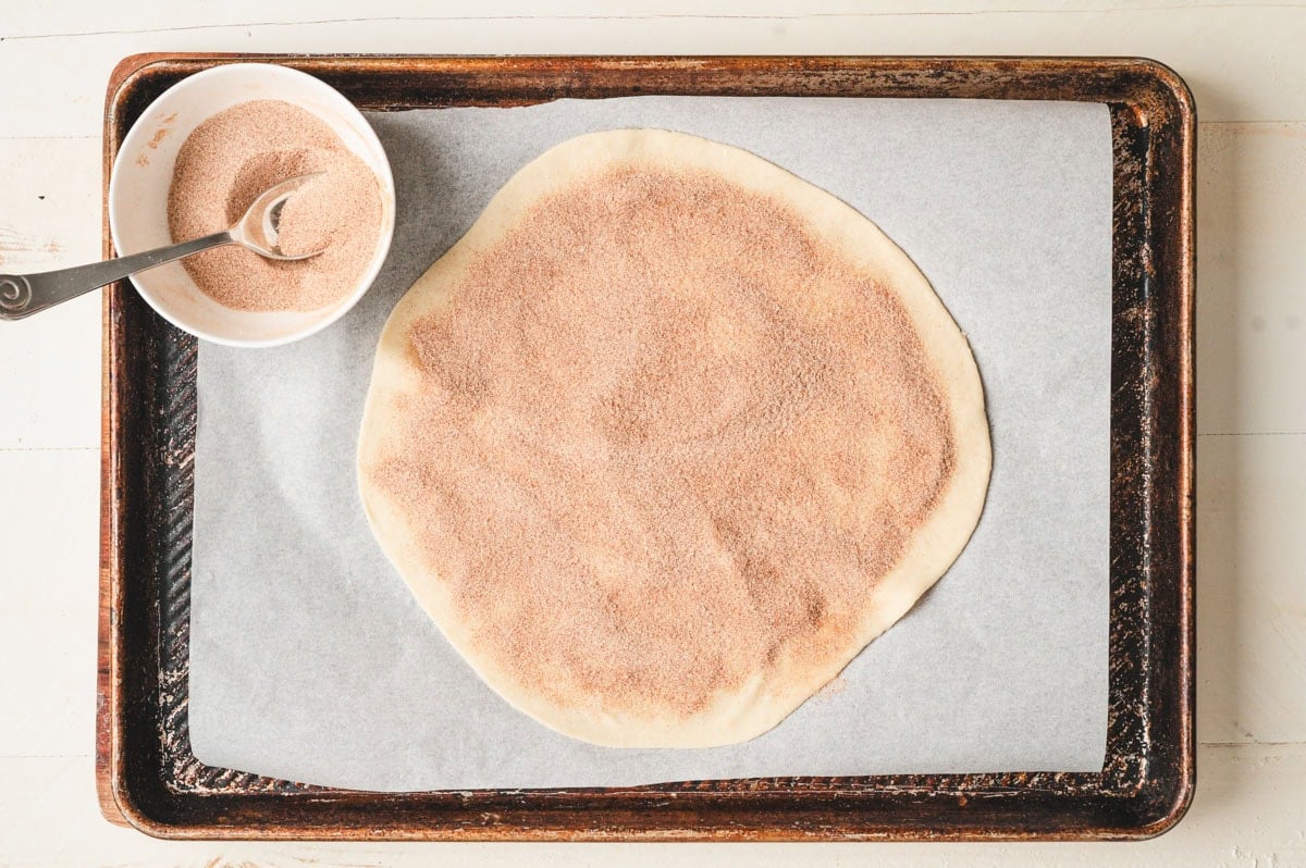 Round circle of dough with cinnamon sugar on top.