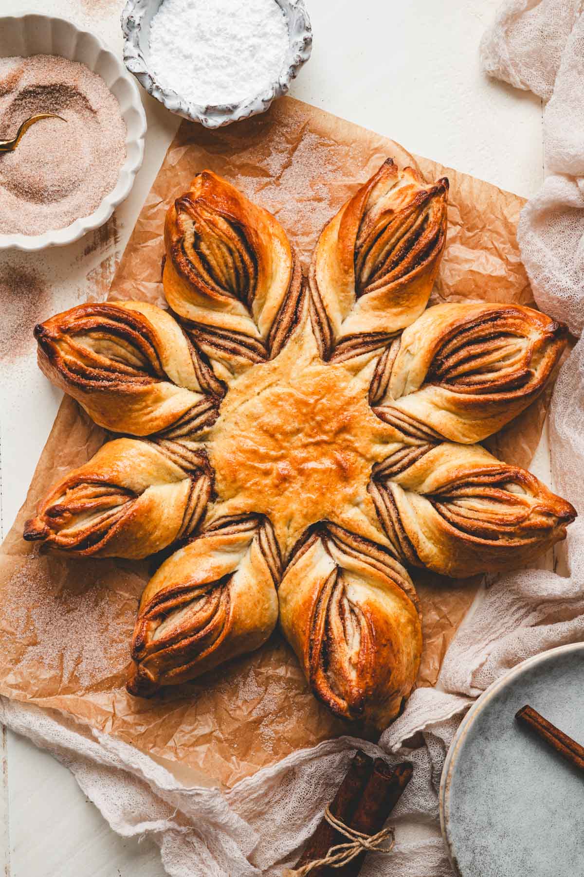 Baked cinnamon star bread on a piece of parchment paper.