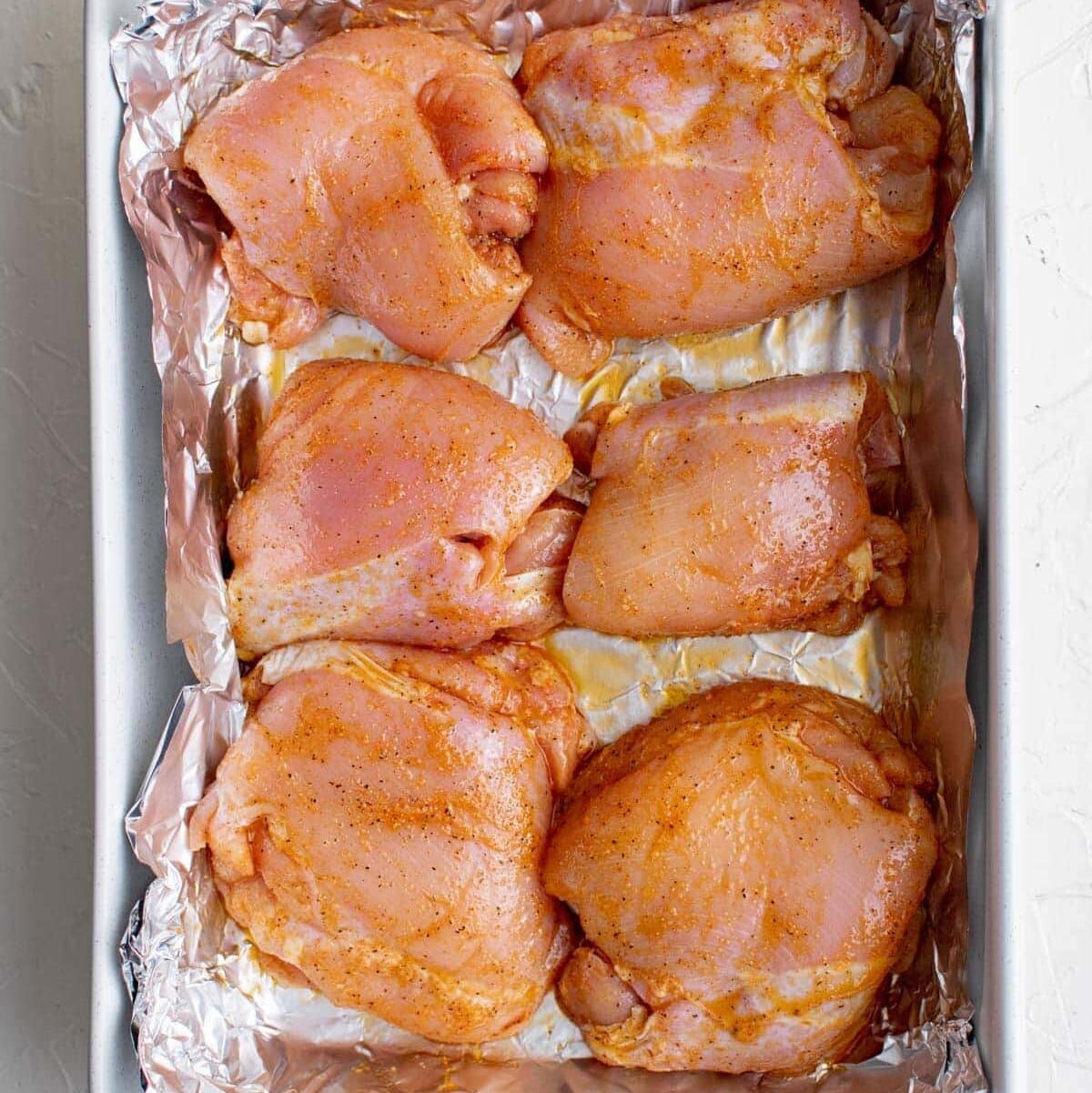 raw boneless chicken thighs, baking dish with foil