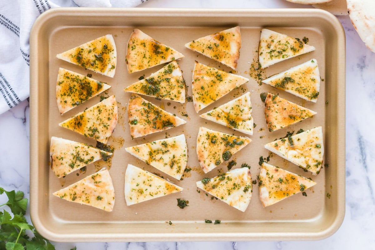 seasoned pita bread on a baking sheet