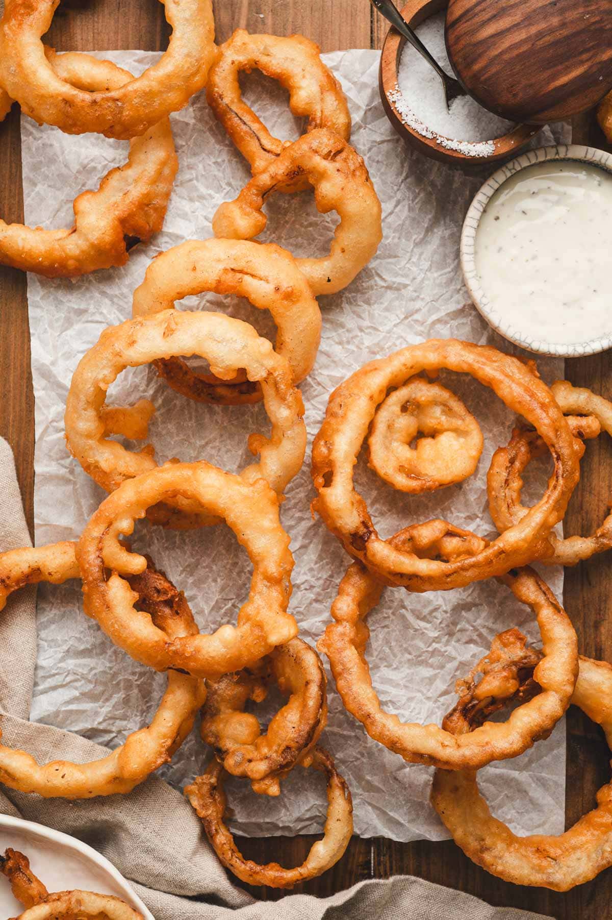 Fried onion rings on parchment paper.
