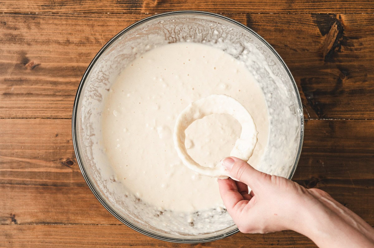 Onion ring being dipped in beer batter