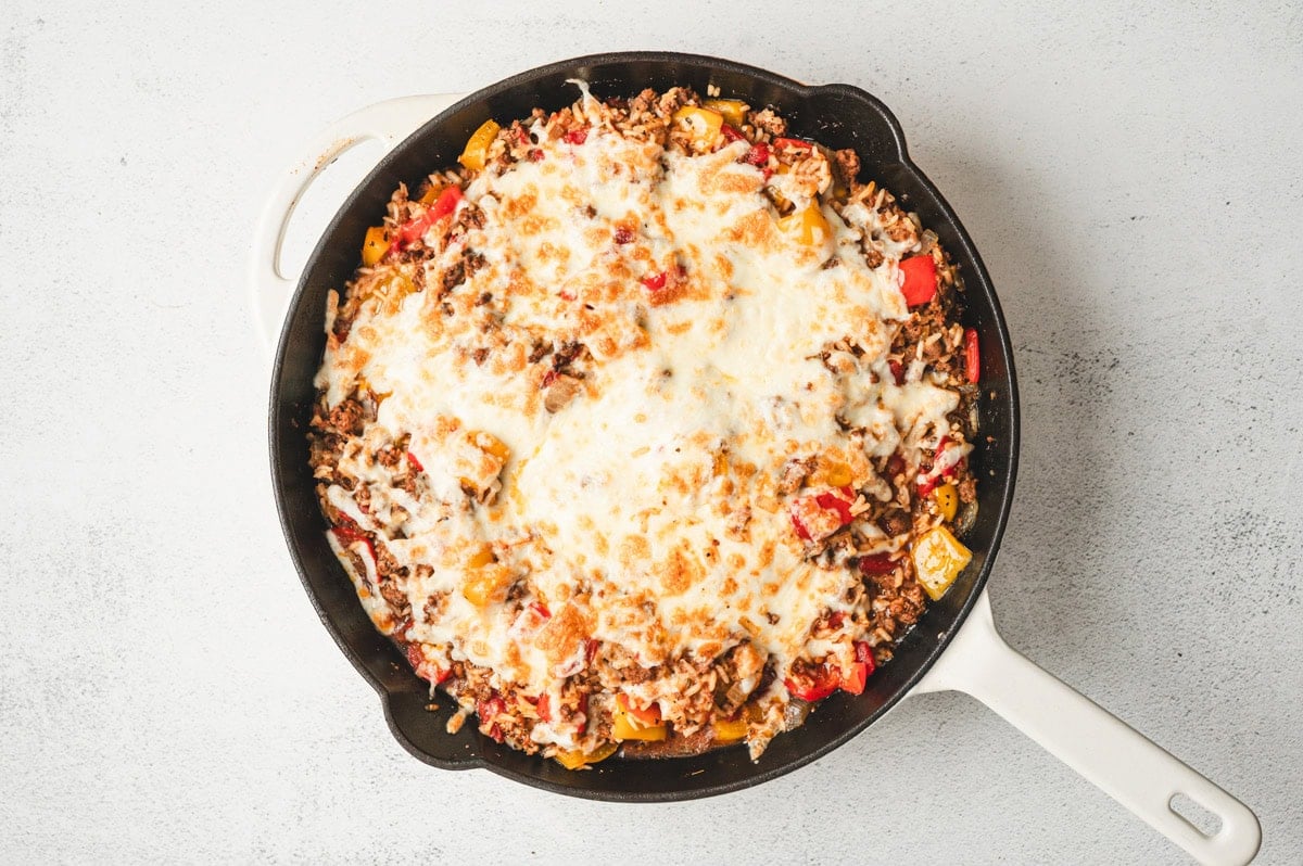 Fully cooked unstuffed pepper casserole with melted cheese on top in skillet.