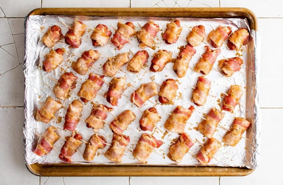 Baked bacon wrapped little smokies on a foil lined sheet pan.