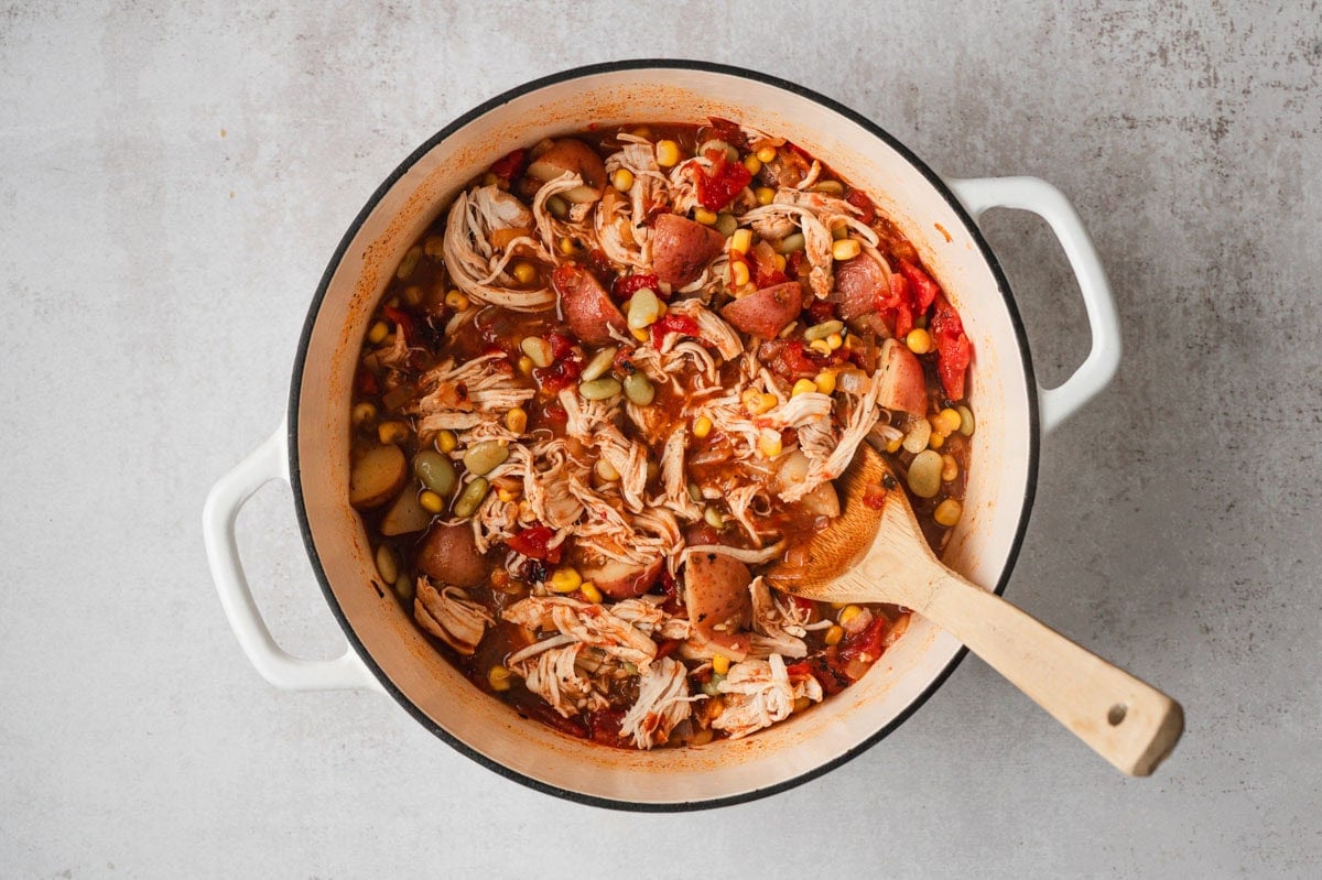 Cooked brunswick stew in a white pot.