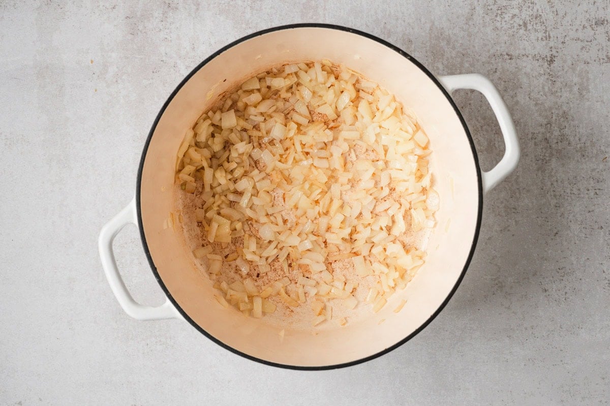 Diced onion cooking in a white pot.