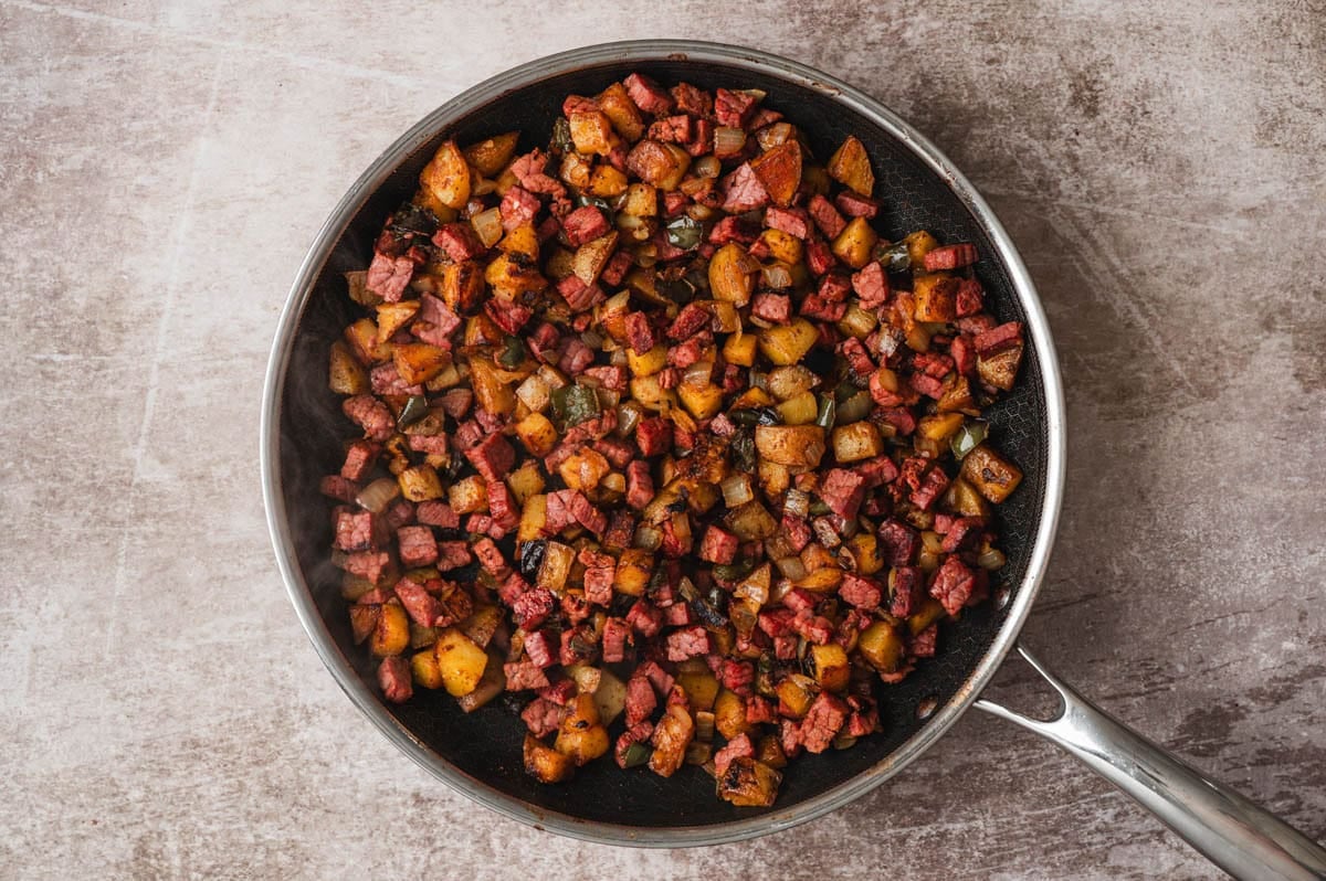 Cooked corned beef hash in a skillet.