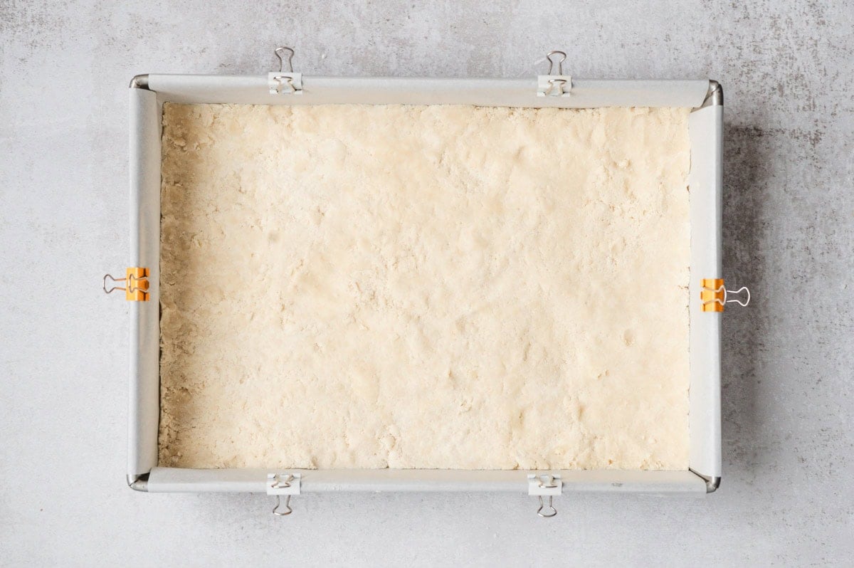 Unbaked shortbread crust pressed firmly in a pan.
