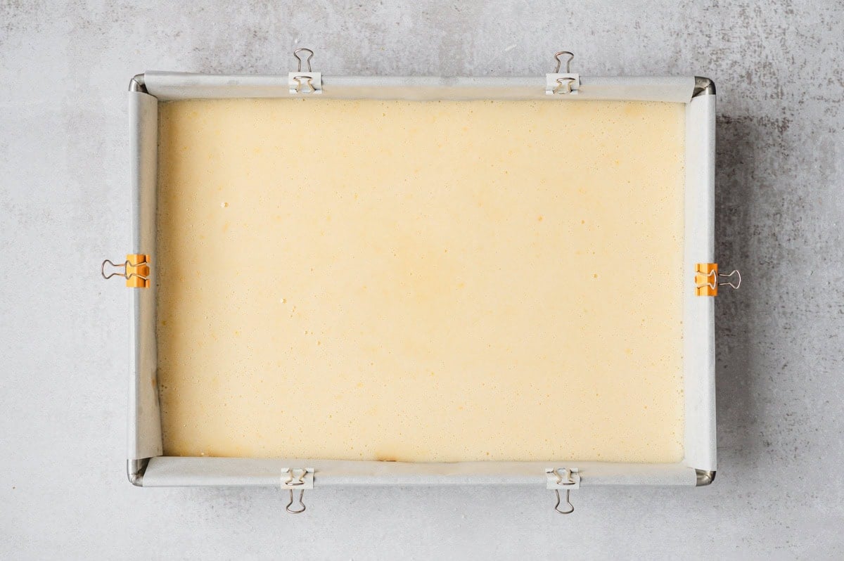 Unbaked lemon bars in a parchment lined pan.