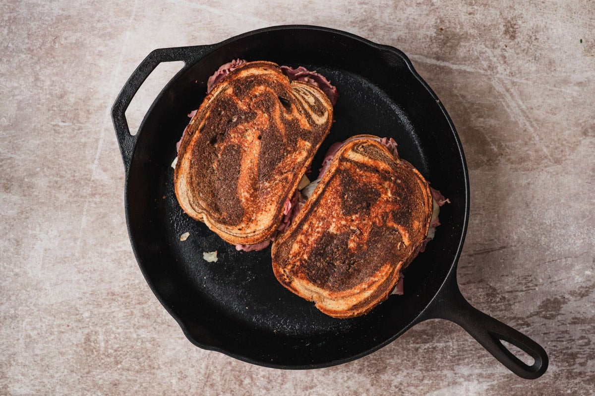 Browned Reuben sandwich in a cast iron skillet