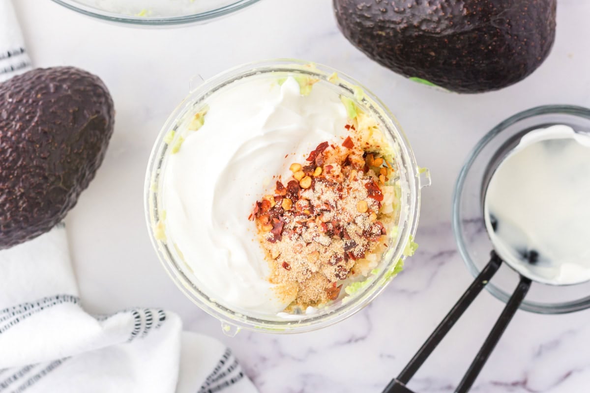 Ingredients for avocado crema in a food processor bowl.