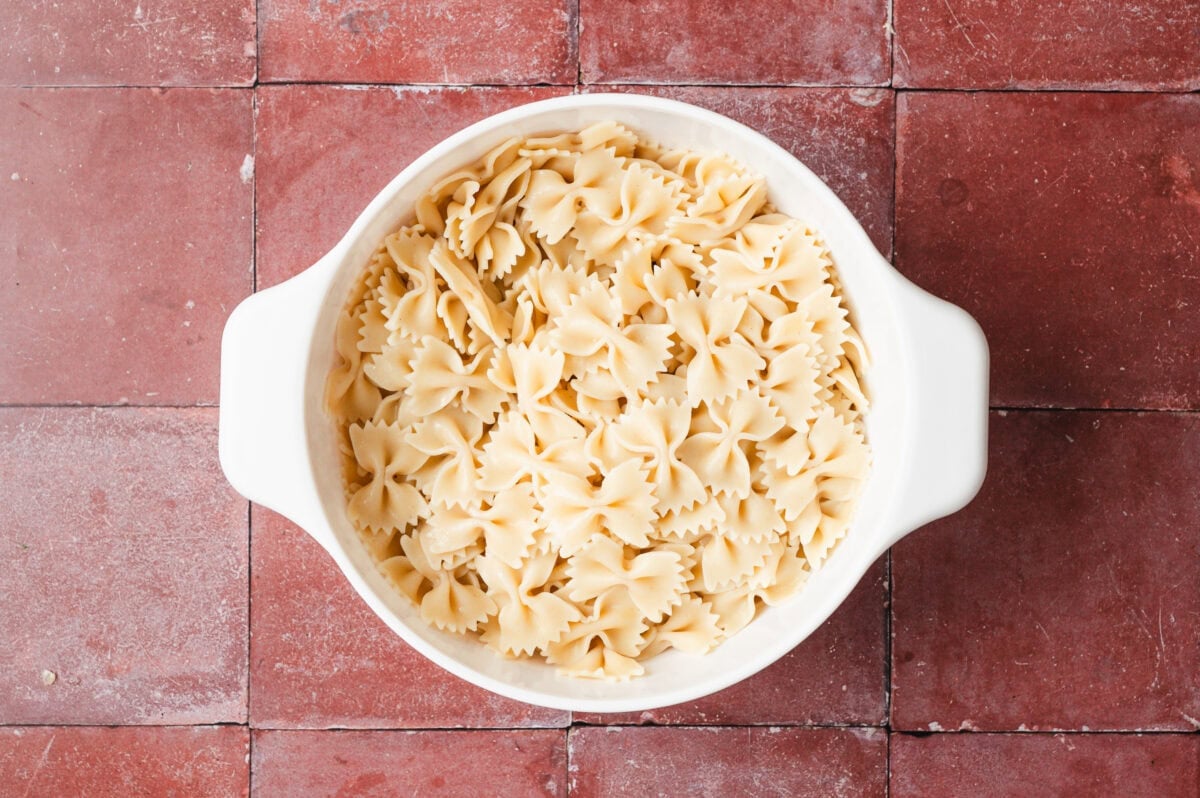 Cooked bowtie pasta in a white dish.