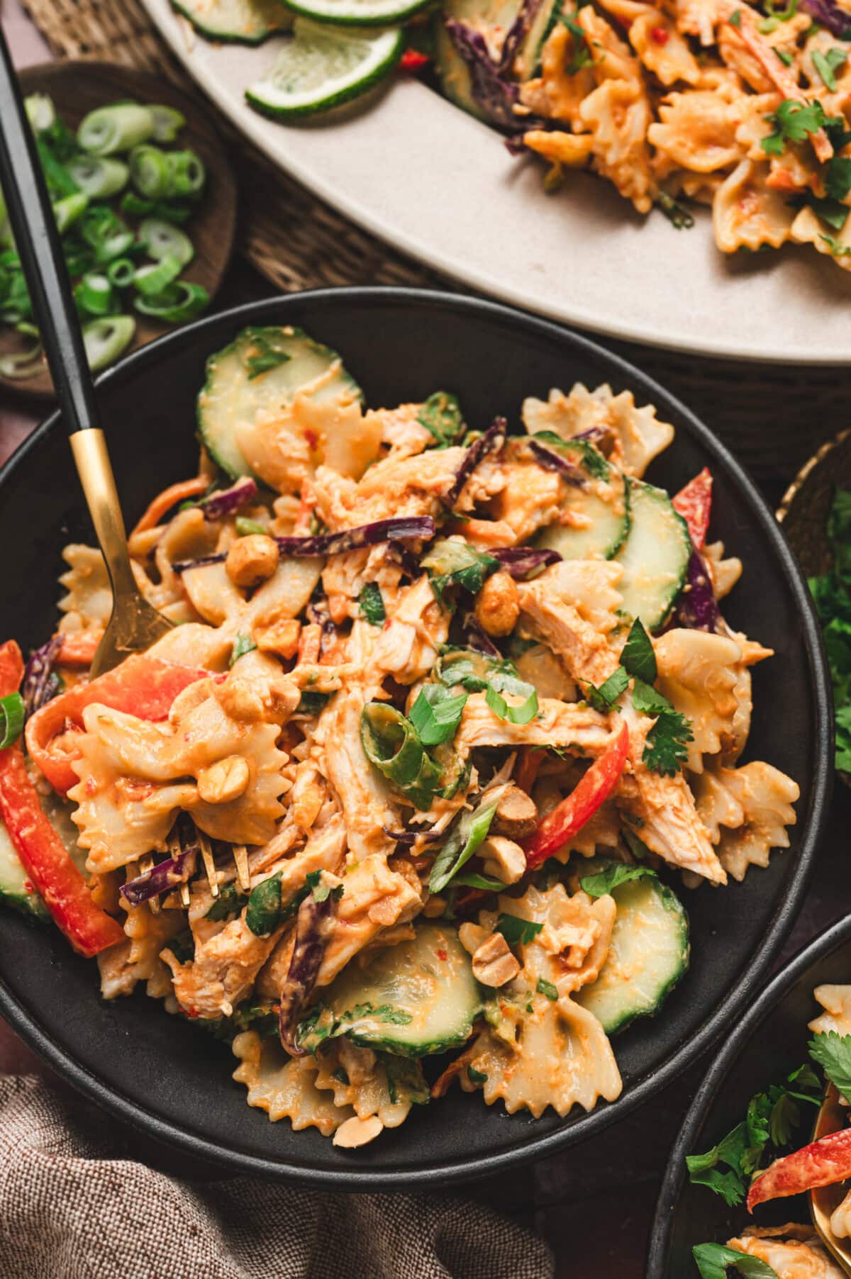 Thai chicken pasta salad on a black plate.