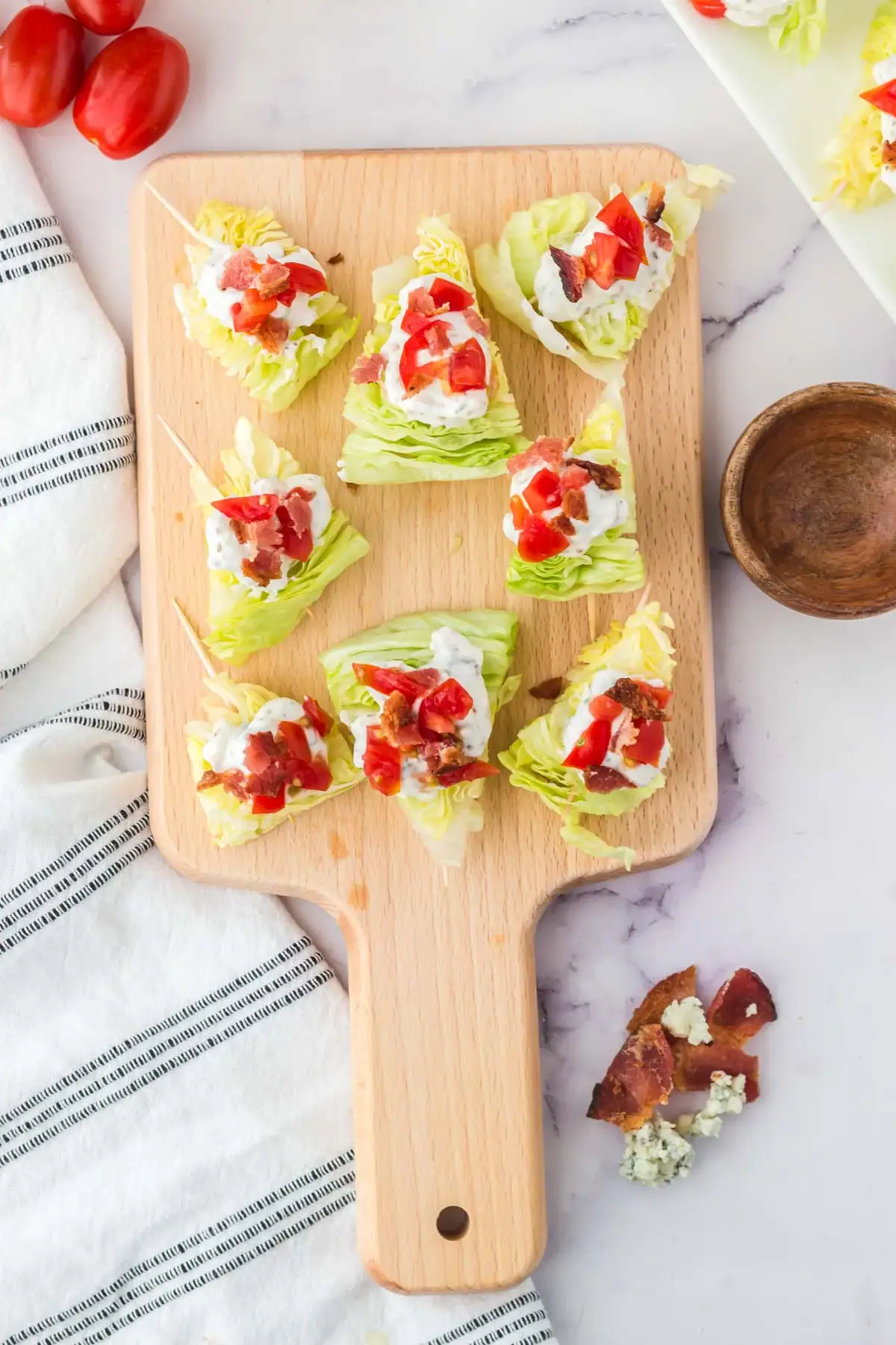 Wedge salad bites on a wooden board.