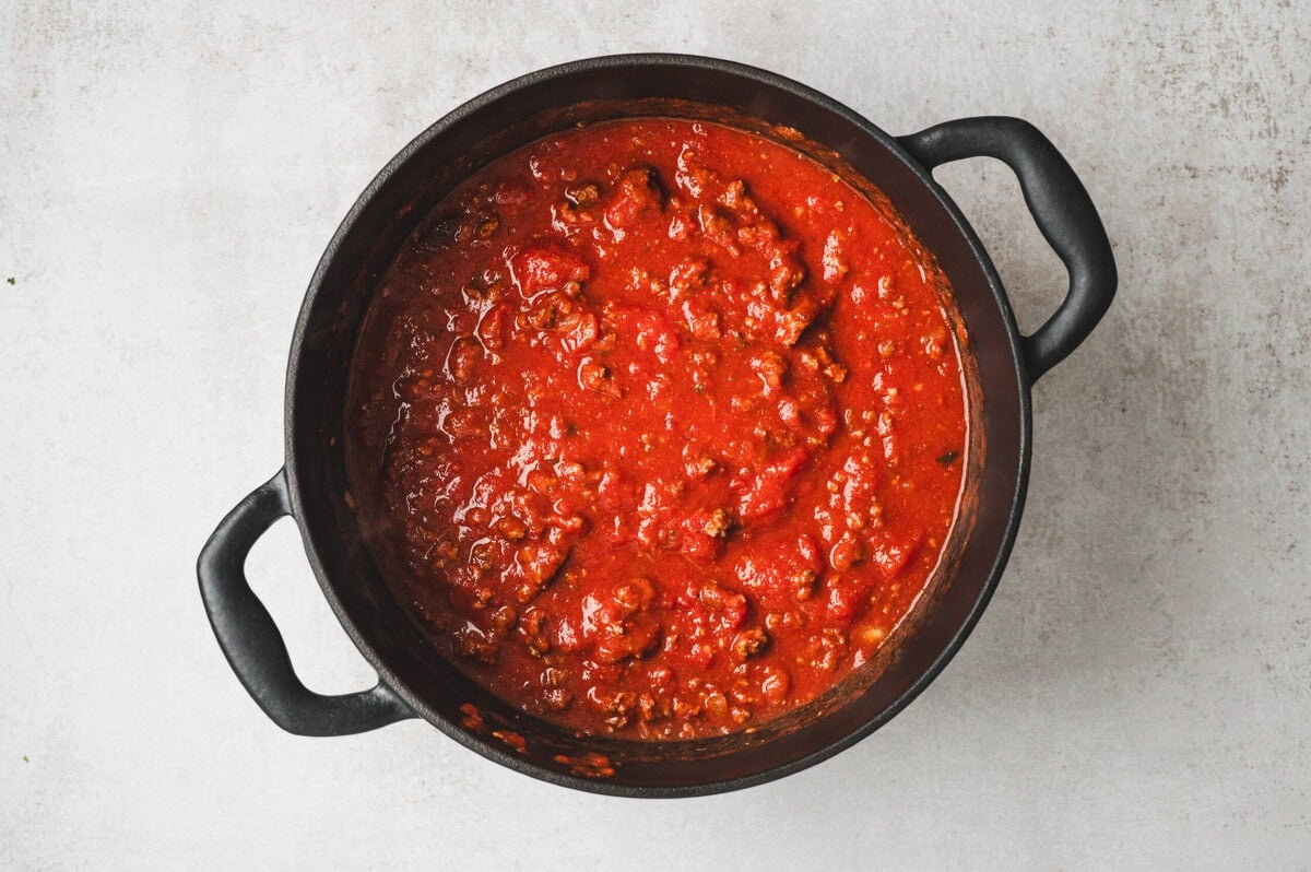 Marinara sauce with meat in a black pot.