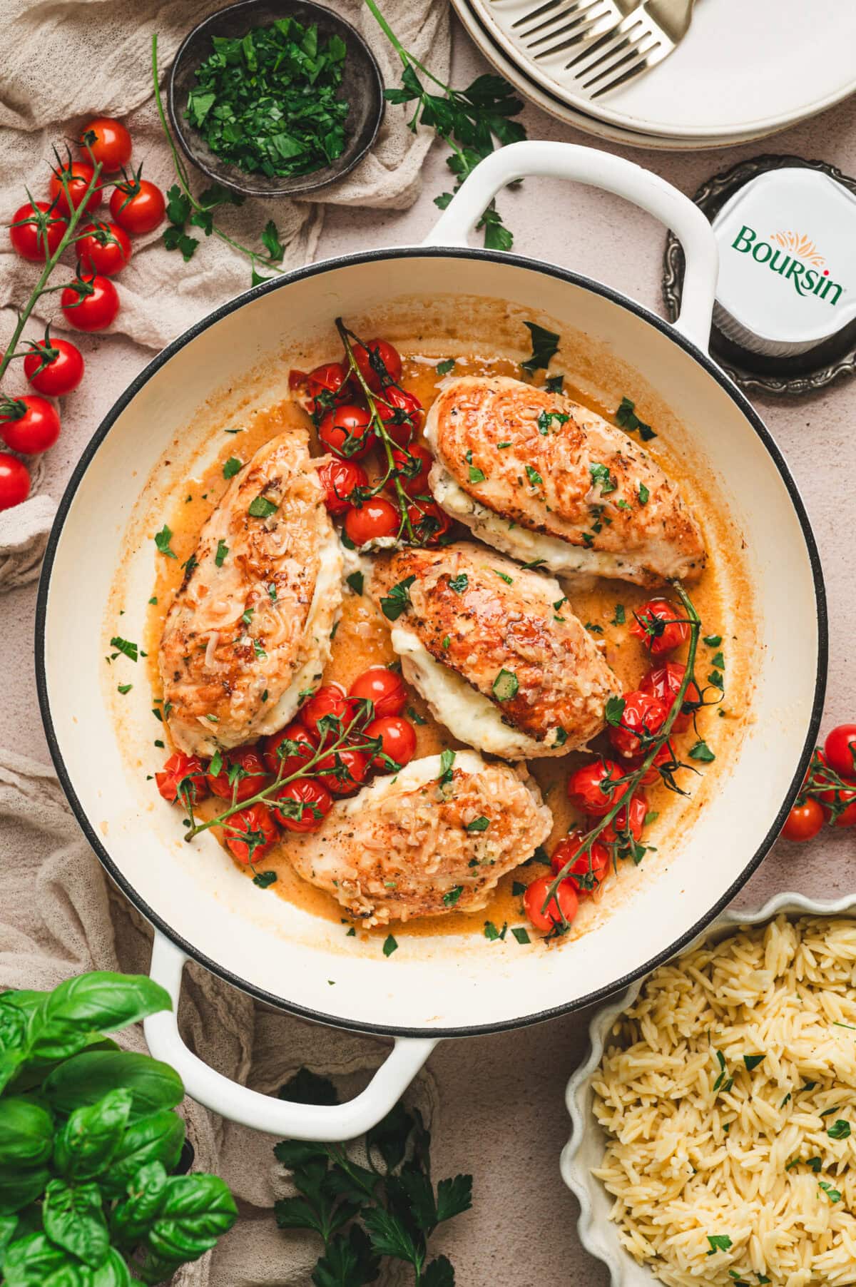 Chicken Breasts stuffed with boursin cheese in a pan with cherry tomatoes.