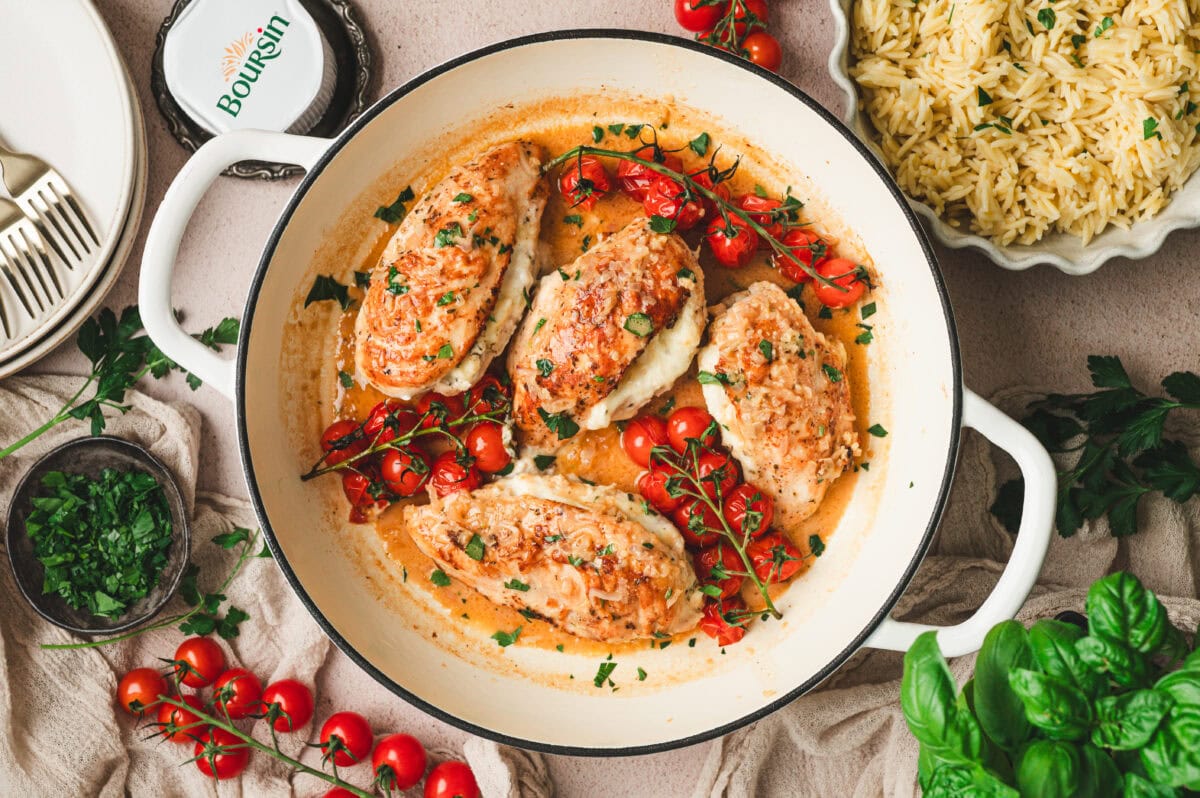 Boursin stuffed chicken cooked in a pan with cherry tomatoes.