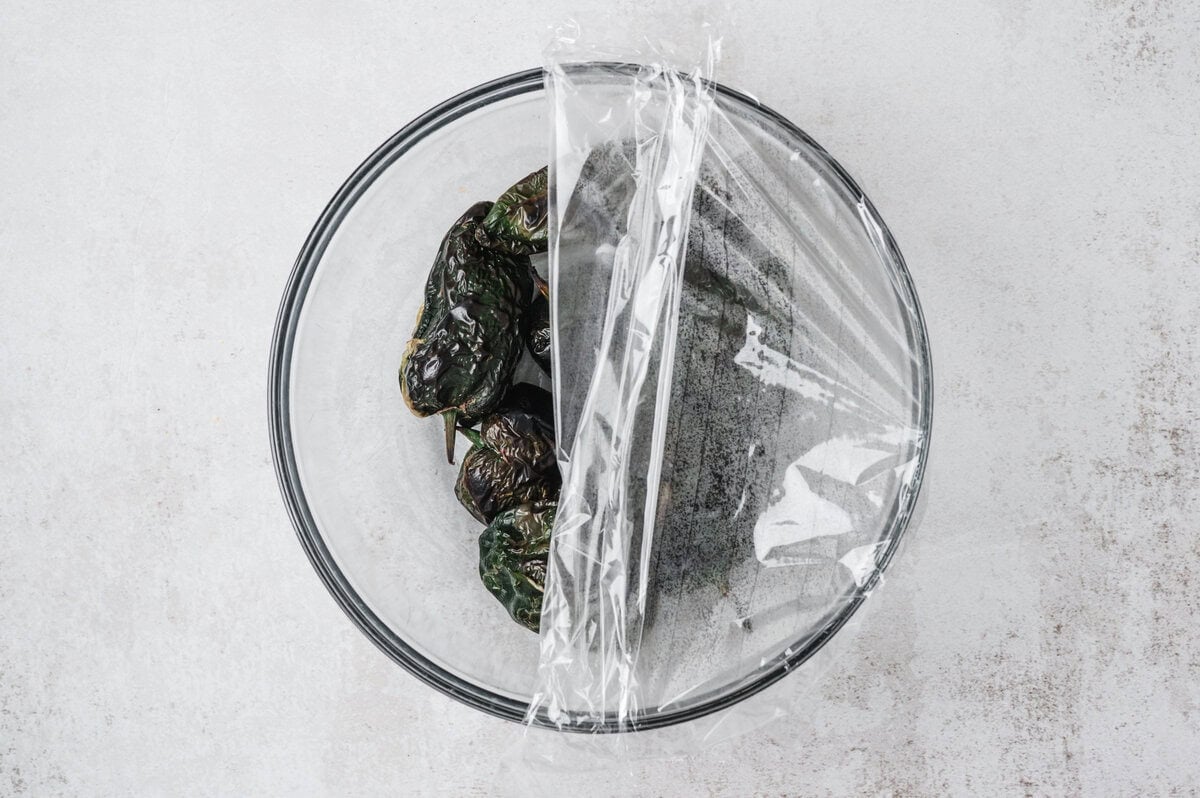 Chiles in a glass bowl covered with plastic wrap