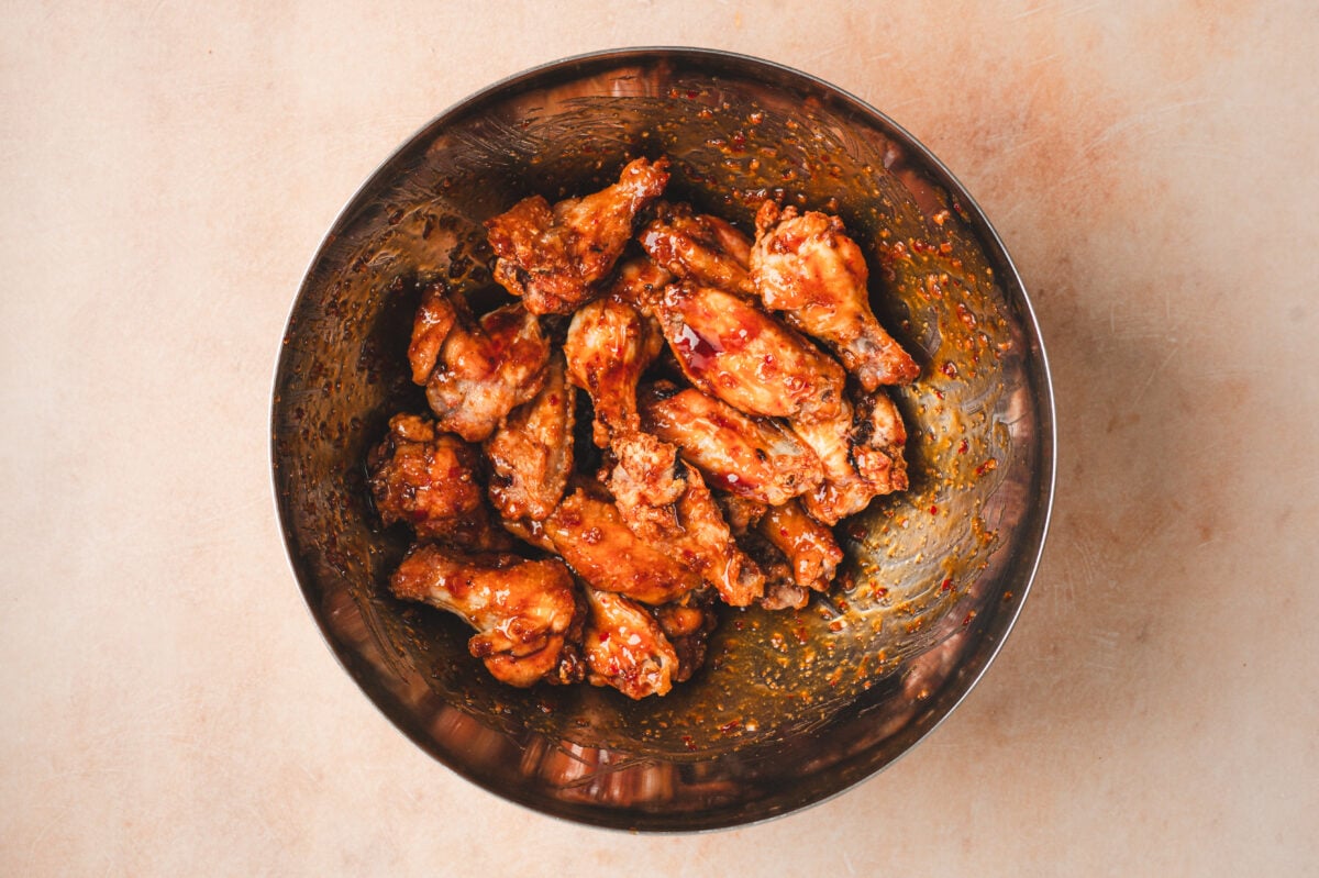 Wings being tossed in a honey garlic sauce
