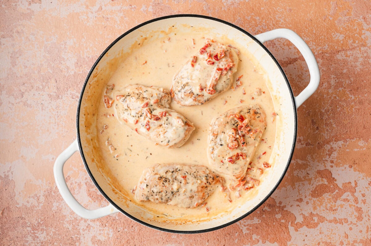 Chicken simmering in thick creamy sauce