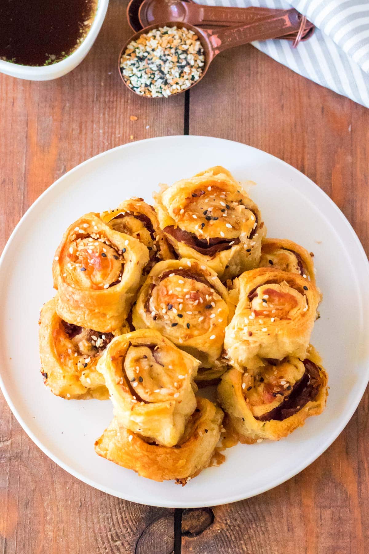 A white plate with french dip pinwheels stacked on top.