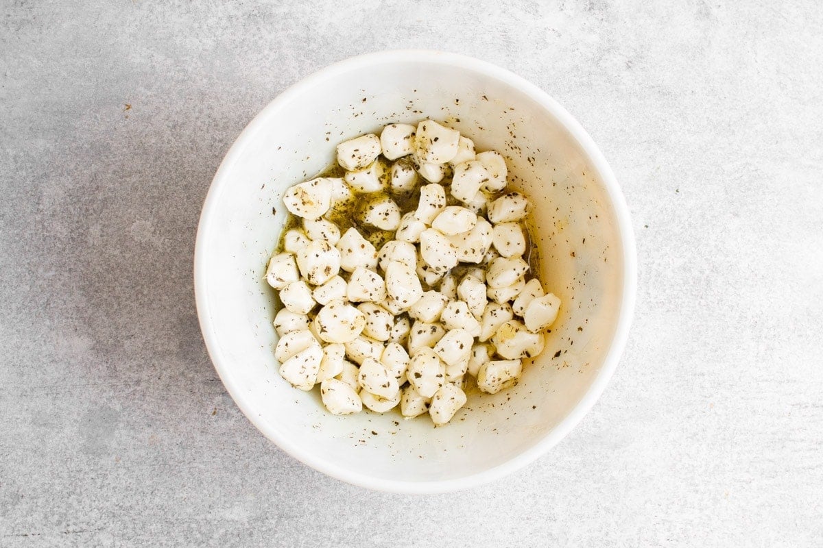 Marinated mozzarella in a white bowl