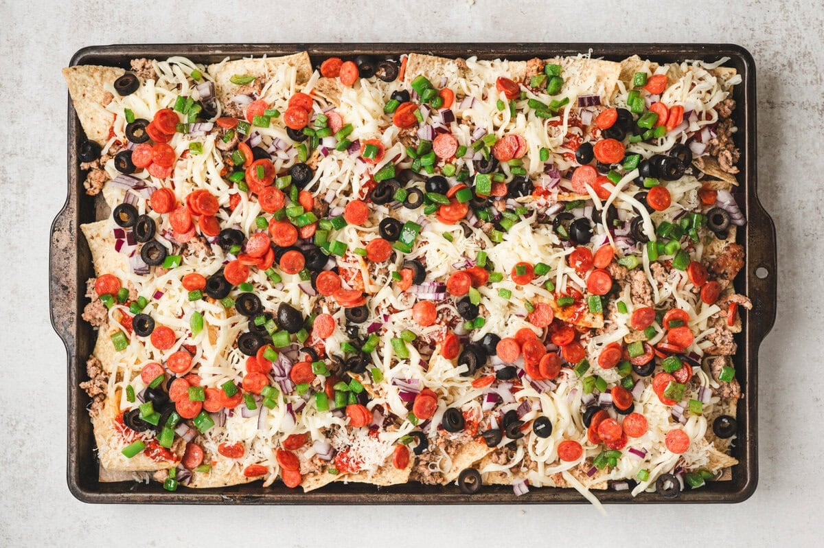 Unbaked sheet pan of loaded pizza nachos