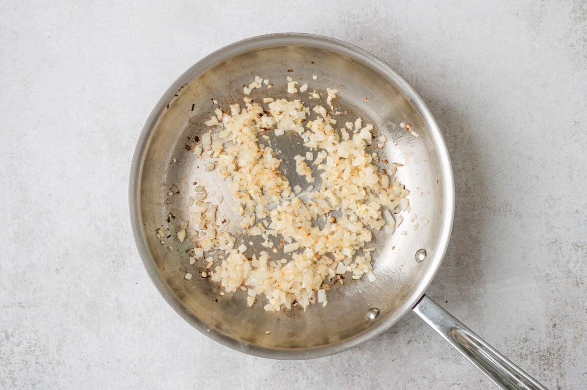 Onion and garlic sauteing in a pan.