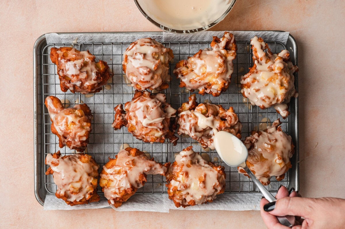 Glazed apple fritters on a wire rack