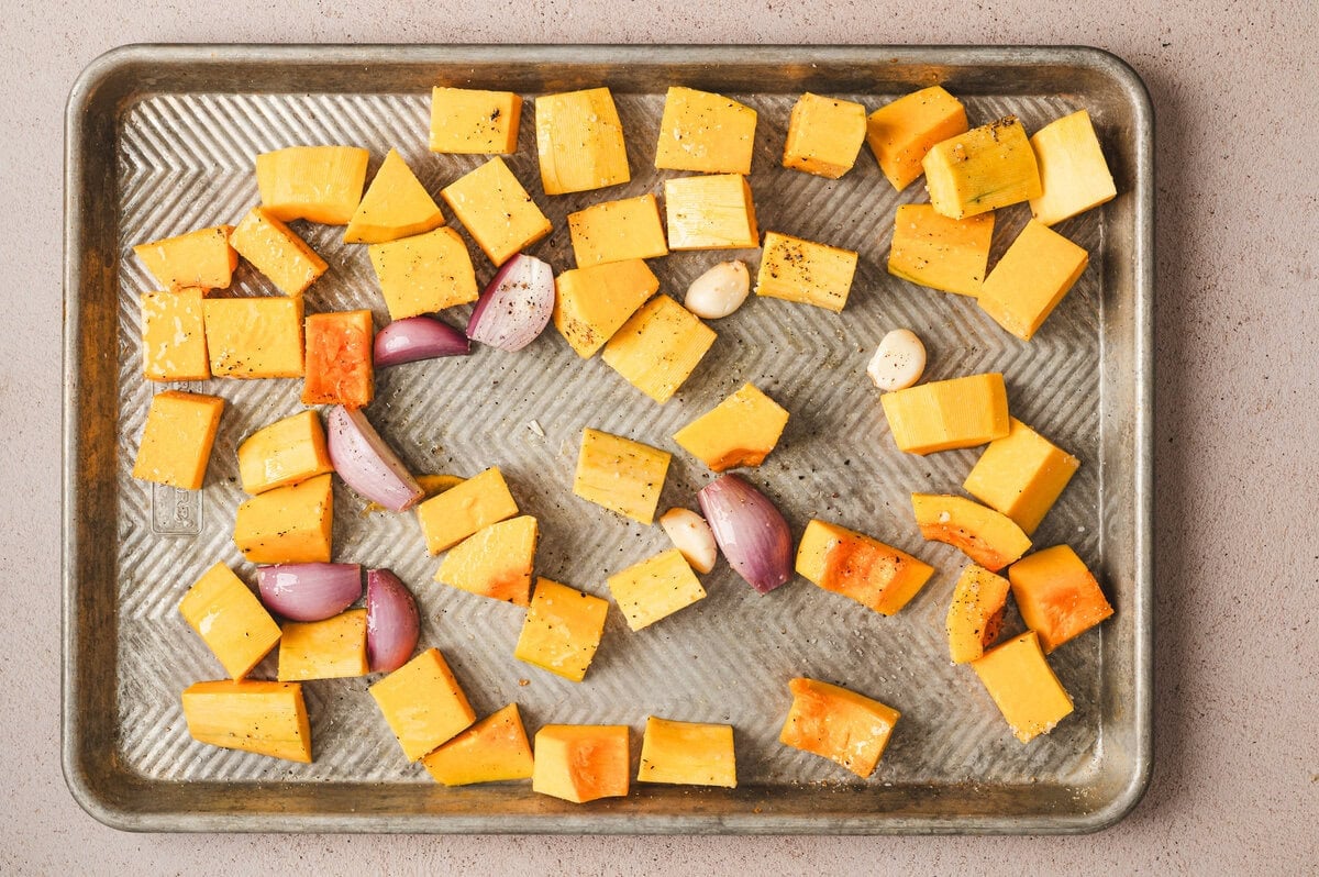 Butternut squash with garlic and shallots on a sheet pan